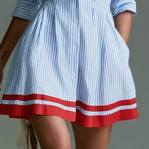 Detail of a blue and white striped shirt dress with a vibrant red hem and side pockets