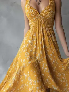 Close-up detail of yellow floral halter dress featuring V-neck and slimming waistline