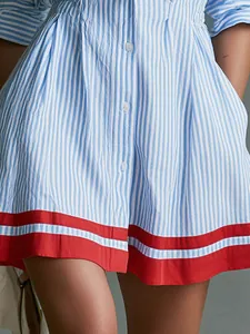 Elegant blue and white striped shirt dress featuring red hem trim and front buttons