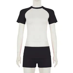 Completo sportivo due pezzi con crop top raglan e pantaloncini neri su manichino