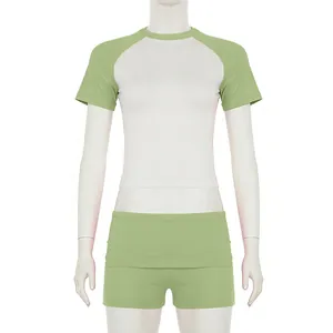 Vista frontale del set sportivo 2 pezzi con maglia raglan e pantaloncini verde chiaro