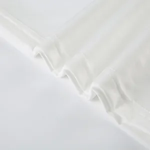 Dettaglio macro del morbido tessuto a maglia bianco e dell'orlo a doppia cucitura del set