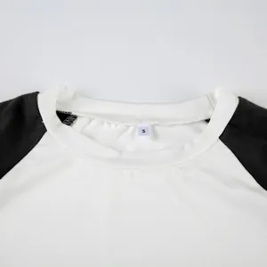 Dettaglio dello scollo della maglietta raglan con etichetta S e cuciture a contrasto