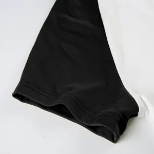 Dettaglio ravvicinato delle cuciture resistenti sulla manica raglan nera di un top sportivo casual.