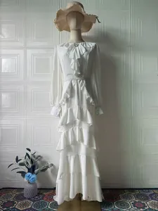 Elegant white long sleeve ruffled maxi dress with high waist and decorative brooch detail