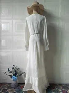 Back view of an elegant white long-sleeved maxi dress with ruffled hem and waist belt