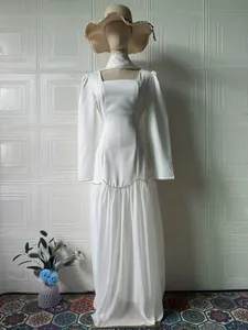 Elegant white long-sleeved maxi dress with square neckline and ruffled skirt details
