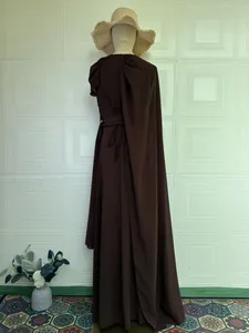 Elegante donkerbruine mouwloze avondjurk met vetersluiting op de rug en cape-detail