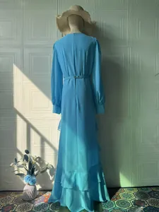 Back view of an elegant blue long-sleeved maxi dress with ruffled hem and waist belt