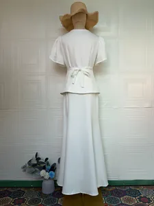 Elegant white two-piece fashion set featuring a short-sleeve top and a floor-length skirt