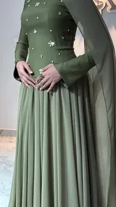 Detailed view of dark green slim-fit dress with pearl floral embellishments and pleats