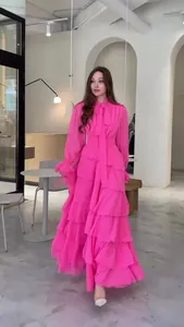 Vue détaillée d'une robe maxi fuchsia à volants avec un élégant nœud papillon au col.