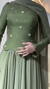 Close-up detail of an elegant olive green slim dress with sparkling crystal floral patterns.