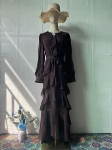 Elegant dark brown long-sleeved tiered maxi dress with waist tie and ruffle details