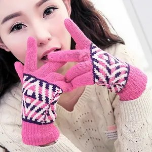 Nahaufnahme einer Frau mit pinkfarbenen Strick-Winterhandschuhen und geometrischen Mustern