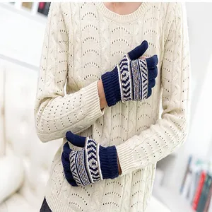 Detail von marineblauen Strickhandschuhen mit Touchscreen-Funktion und geometrischem Muster.