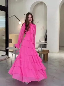 Robe longue à volants fuchsia élégante avec col à nœud et manches longues.