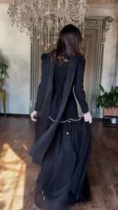 Back view of an elegant black long-sleeved palace style vintage dress with pearl details