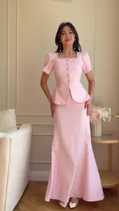 Elegant light pink two-piece set featuring a short-sleeved peplum top and mermaid skirt.