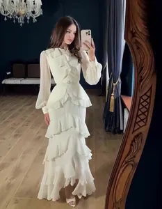 Full view of an elegant white long sleeve tiered ruffled maxi dress in a mirror selfie.
