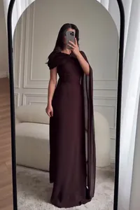 Elegante chocoladebruine mouwloze avondjurk met gedrapeerde schoudercape als detail