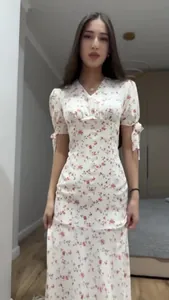Primo piano dell'abito floreale bianco con scollo a V e maniche con fiocco rosa