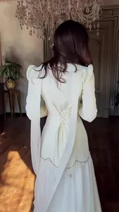Back view of a vintage palace style long-sleeved dress with lace-up waist detail