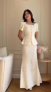 Elegant two-piece cream set with peplum top and mermaid skirt, square neck detail