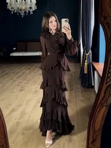 Elegant dark brown long-sleeved maxi dress with feminine ruffles and a cinched waistline