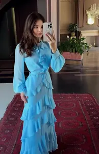 Full-length view of elegant light blue ruffled maxi dress in luxury indoor setting