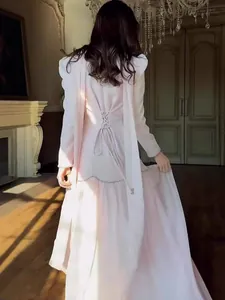 Elegant vintage palace style long-sleeved dress in soft pink with detailed corset lace-up back