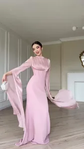 Detail van elegante roze zijden jurk met uitlopende mouwen en soepele stof