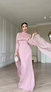 Detail van een elegante lange satijnen jurk in mauve met wijde mouwen en getailleerd.