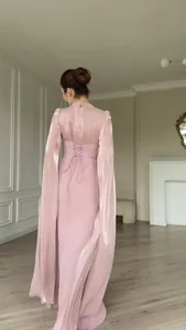 Gedetailleerd achteraanzicht van een elegante roze jurk met vetersluiting en lange mouwen