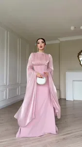 Detail van een elegante roze satijnen maxi-jurk met lange en wijde, soepele mouwen