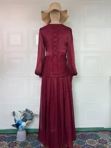 Detailed back view of an elegant long-sleeved burgundy maxi dress featuring lace-up design