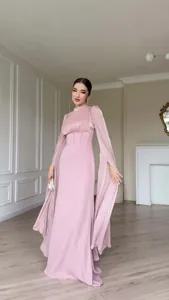 Detailweergave van een elegante roze zijdeachtige maxi-jurk met lange mouwen op een model