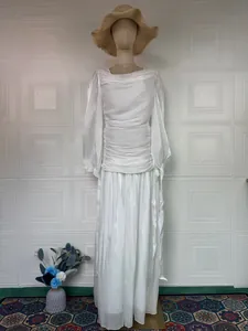 Detailed texture of elegant white long-sleeved maxi dress with ruched design