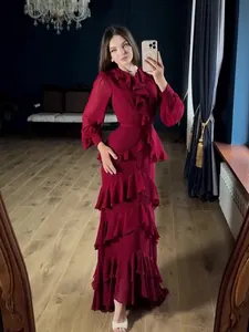 Elegant long-sleeved ruffled tiered red maxi dress for women in a formal evening setting.