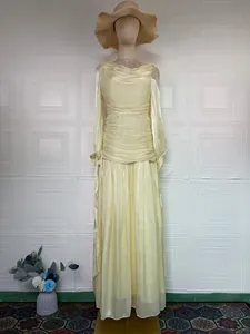 Detailed view of an elegant French style pleated yellow long sleeve maxi dress model