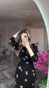 Détail d'une élégante robe noire à fleurs portée par un mannequin lors d'un selfie