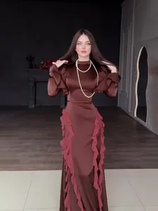 Elegante bruine satijnen maxi-jurk met opstaande kraag, roze ruches en lange mouwen