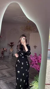 Vue détaillée montrant l'élégante robe noire à imprimé fleuri dans un intérieur chic