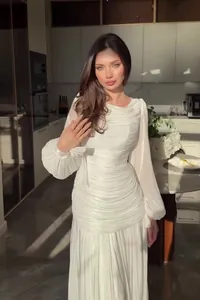 Elegant white French dress with ruched details and puff sleeves in a sunny interior