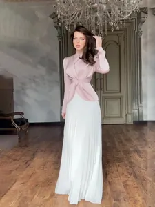 Elegante tweekleurige maxi-jurk met lange mouwen, plissérok en gedraaid detail in de taille