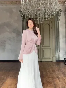 Elegante tweedelige jurk met roze getailleerde top en witte geplooide lange rok.