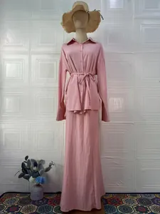Detail view of the elegant pink long-sleeved shirt and maxi skirt set for summer.
