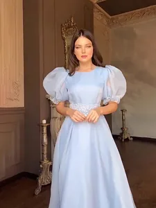 Elegante abito lungo azzurro con maniche a sbuffo e vita decorata