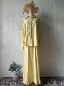Elegant yellow two-piece set featuring long sleeve button shirt and matching maxi skirt.