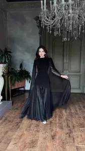 Elegant black floor-length dress featuring graceful cape sleeves in an ornate interior